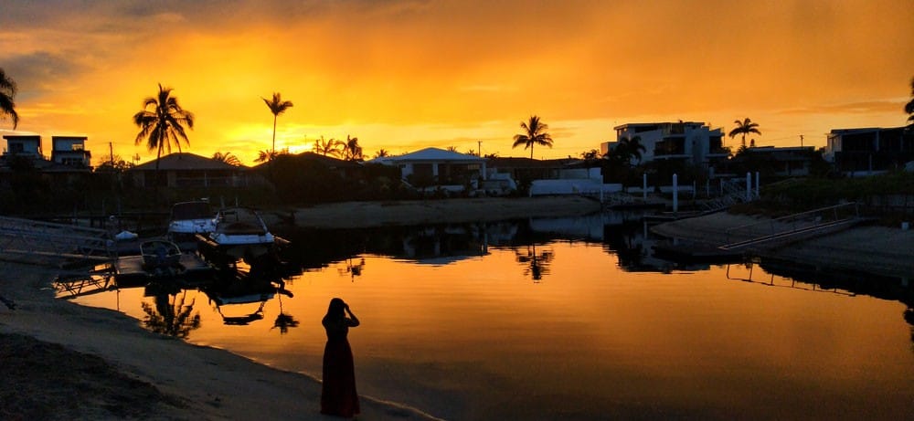 chica tomando foto en atardecer